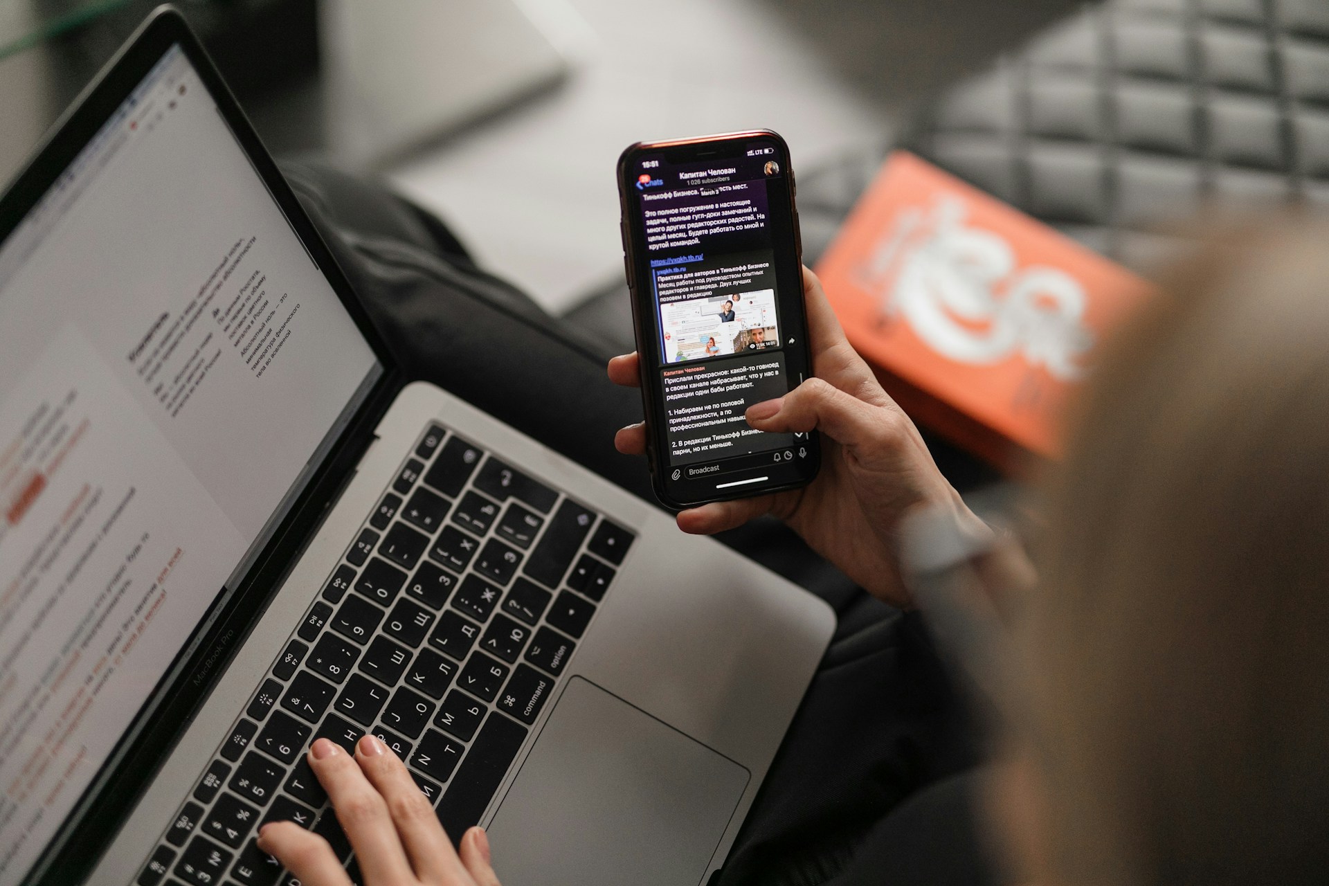 User am Notebook mit Smartphon und Whatsapp Newseltter (maxim-ilyahov-0aRycsfH57A-unsplash)